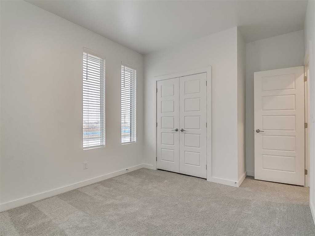 8004 NW 152nd Street, Edmond, OK 73013 unfurnished bedroom with light carpet and a closet