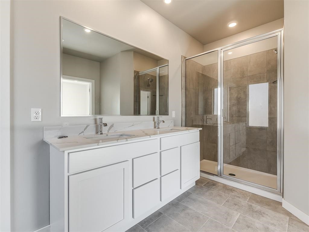 8112 NW 153rd Street, Edmond, OK 73013 bathroom with walk in shower, double vanity, and tile flooring