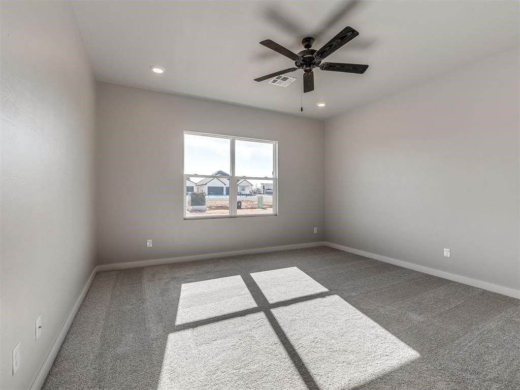 8112 NW 153rd Street, Edmond, OK 73013 carpeted empty room with ceiling fan