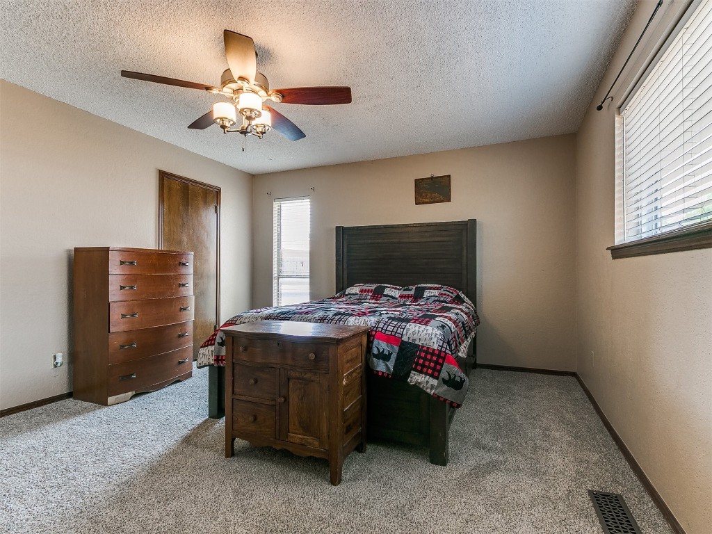 136 Sequoia Park Drive, Yukon, OK 73099 carpeted bedroom featuring a textured ceiling and ceiling fan