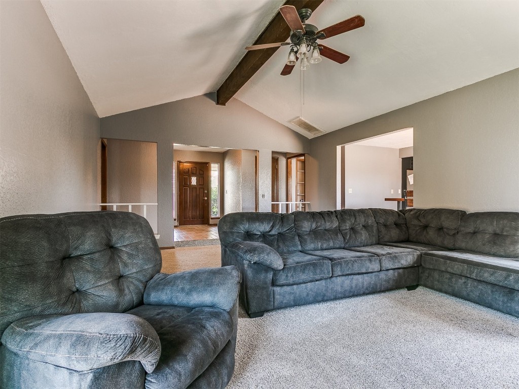 136 Sequoia Park Drive, Yukon, OK 73099 carpeted living room featuring ceiling fan and vaulted ceiling with beams