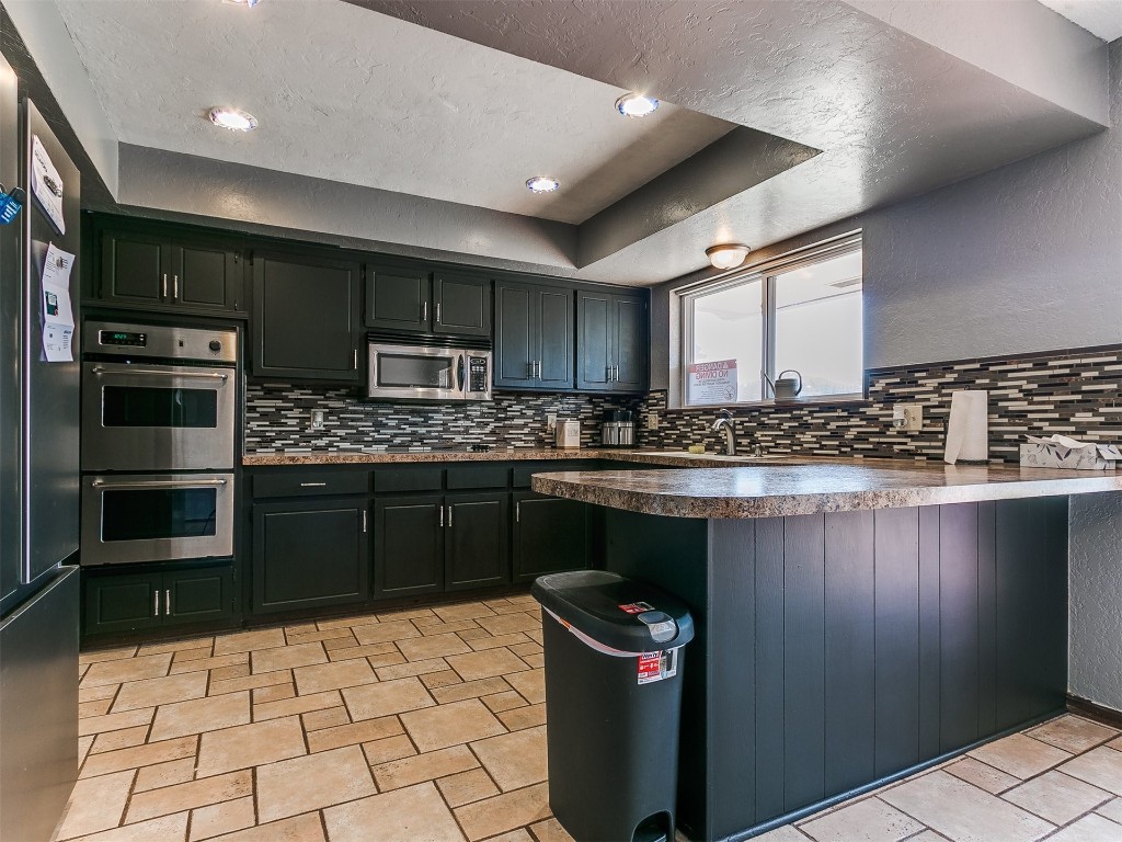136 Sequoia Park Drive, Yukon, OK 73099 kitchen featuring backsplash, stainless steel appliances, and light tile floors