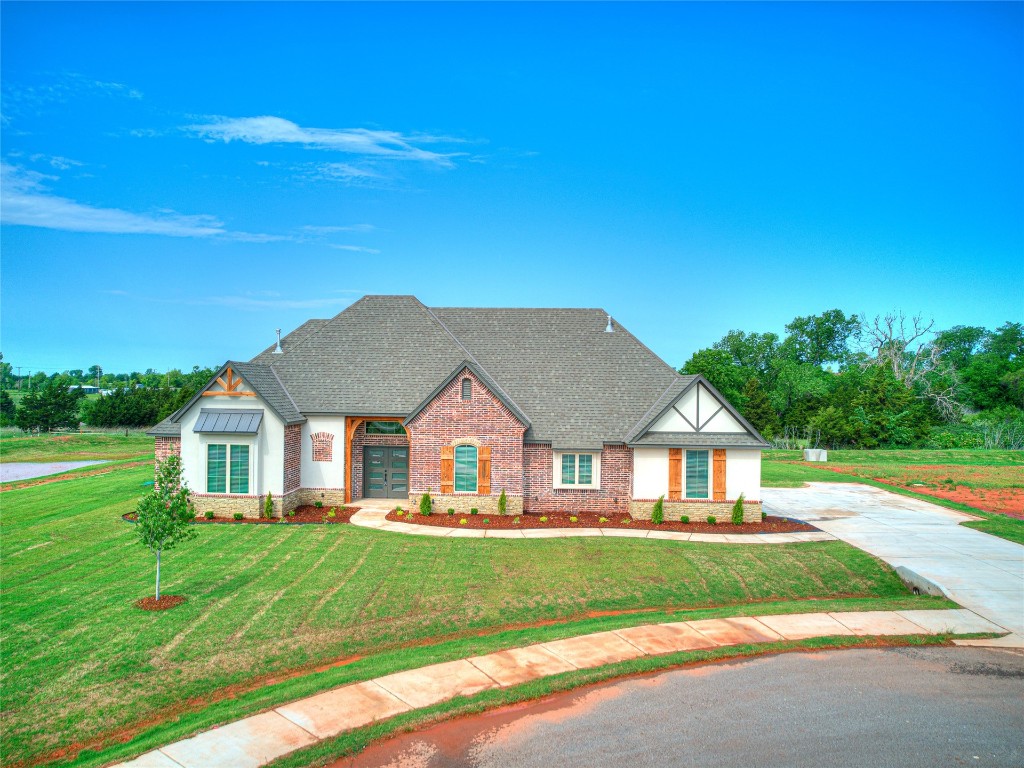 1391 S Kenzie Ct Drive, Mustang, OK 73064 view of front of property featuring a front lawn and a garage