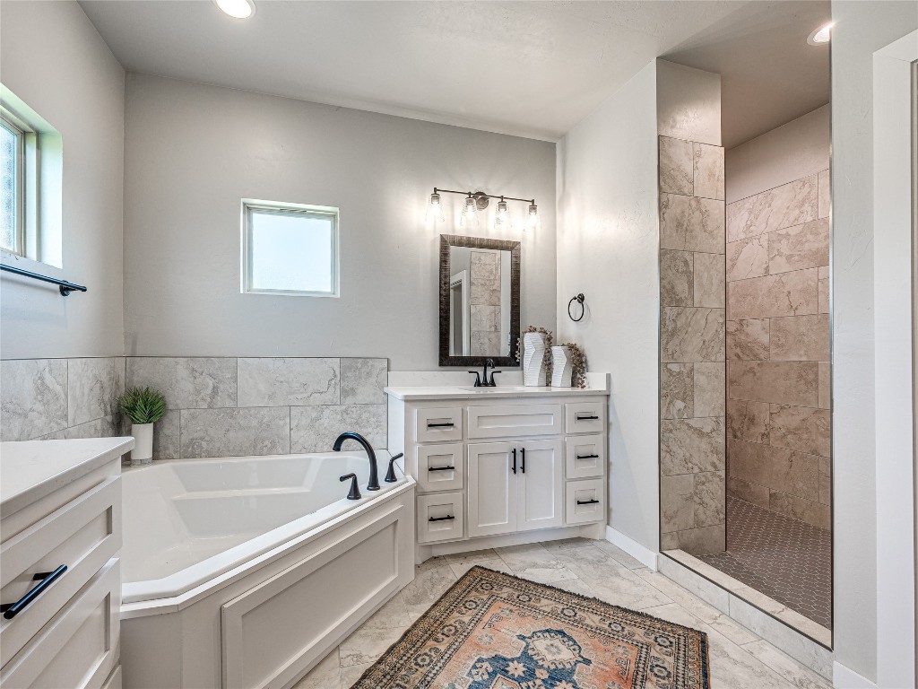 1391 S Kenzie Ct Drive, Mustang, OK 73064 bathroom featuring separate shower and tub, vanity with extensive cabinet space, and tile flooring