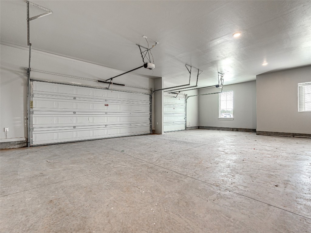 1391 S Kenzie Ct Drive, Mustang, OK 73064 garage featuring a garage door opener
