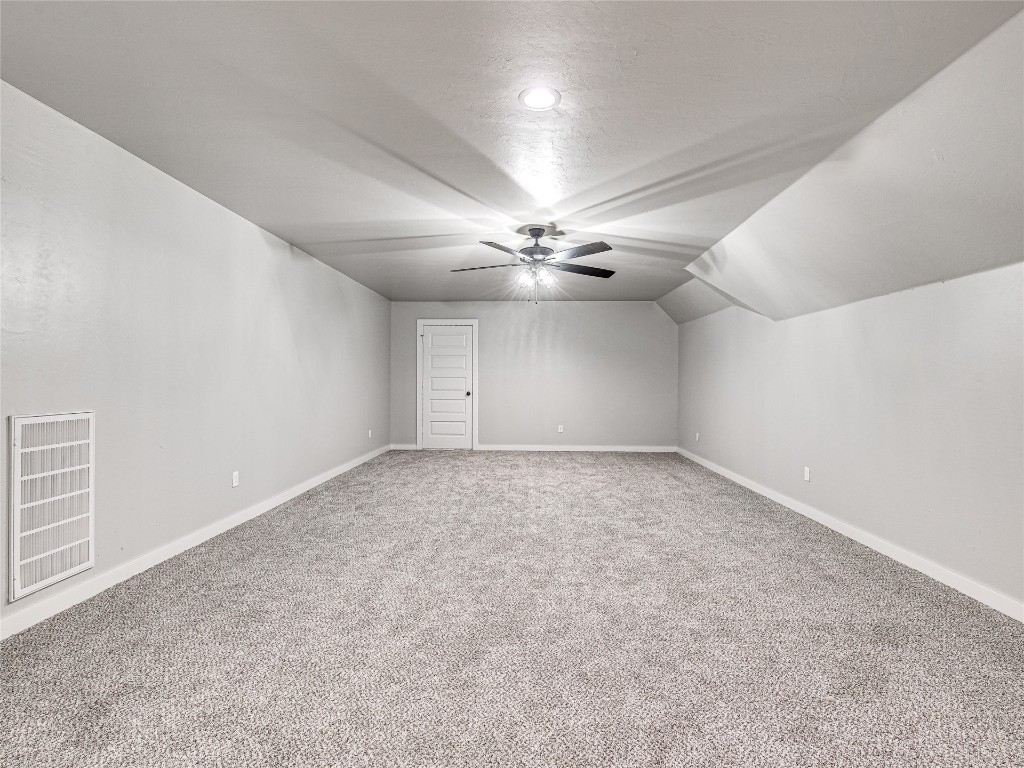 1391 S Kenzie Ct Drive, Mustang, OK 73064 bonus room featuring vaulted ceiling, ceiling fan, and carpet floors