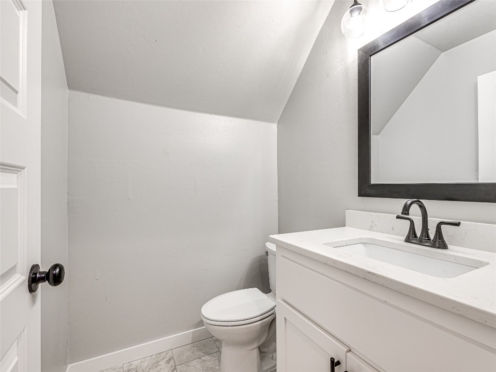 1391 S Kenzie Ct Drive, Mustang, OK 73064 bathroom with toilet, tile flooring, vanity, and lofted ceiling