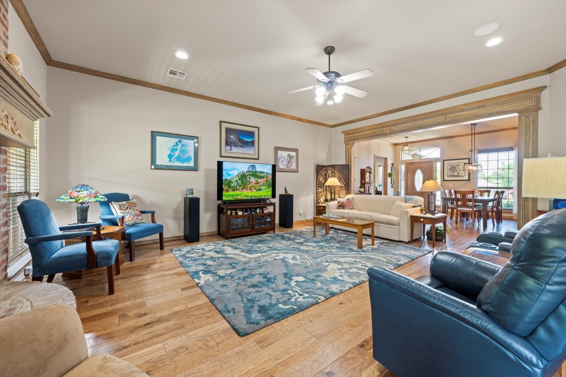 1816 Redland Drive, Edmond, OK 73003 living room featuring ornamental molding, light hardwood / wood-style flooring, and ceiling fan