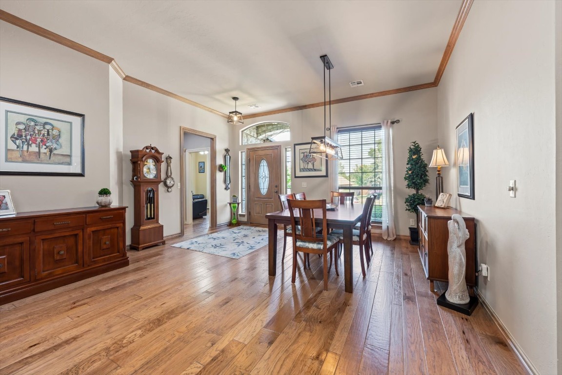 1816 Redland Drive, Edmond, OK 73003 dining area featuring hardwood / wood-style flooring and ornamental molding