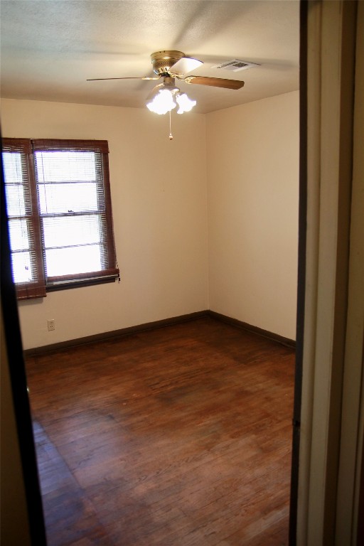 1307 N Broad Street, Guthrie, OK 73044 spare room featuring ceiling fan and dark wood-type flooring