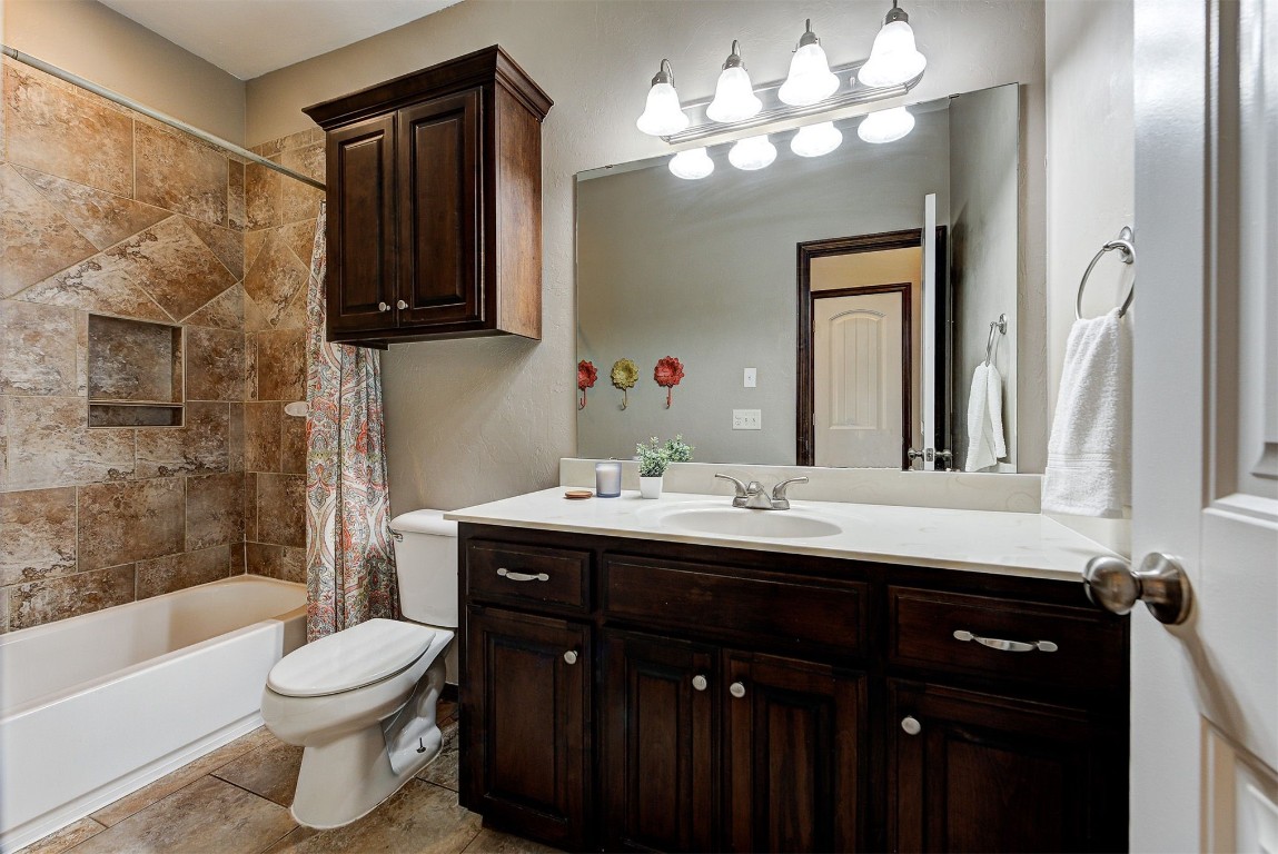 820 White Tail Court, Guthrie, OK 73044 full bathroom featuring toilet, tile floors, vanity, and shower / tub combo with curtain