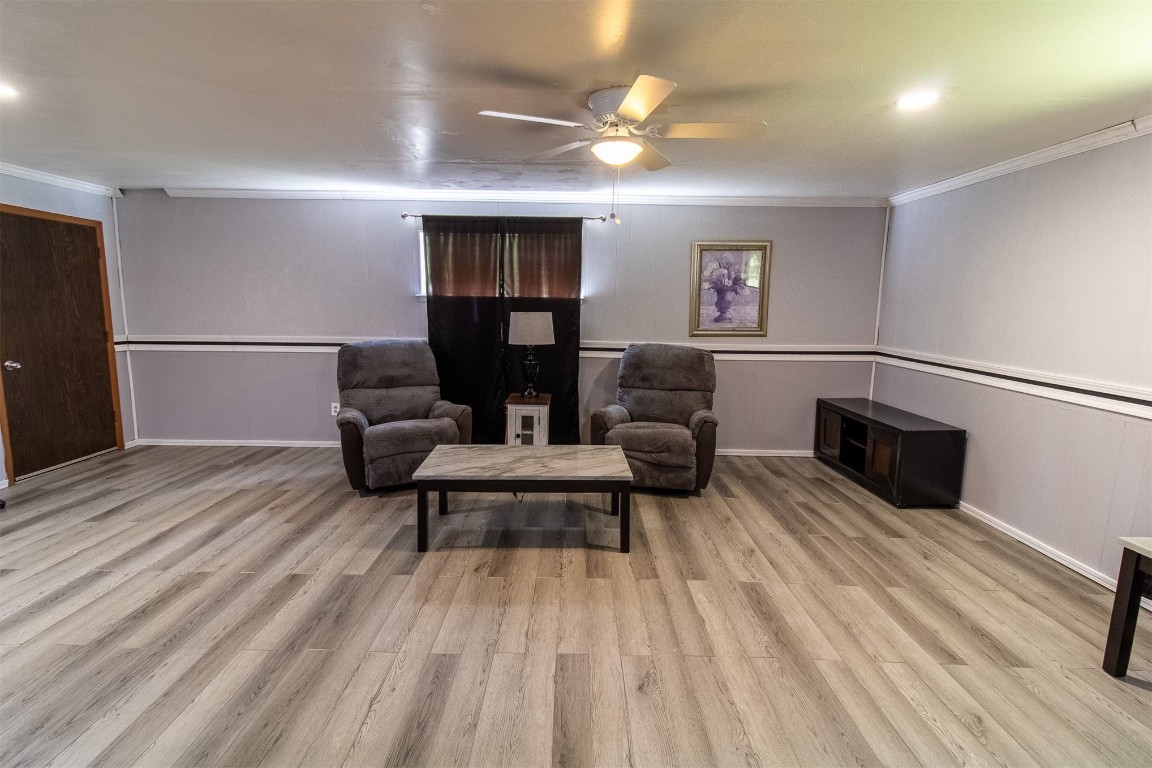 119 W Tennyson Avenue, Tecumseh, OK 74873 sitting room featuring light hardwood / wood-style floors, crown molding, and ceiling fan