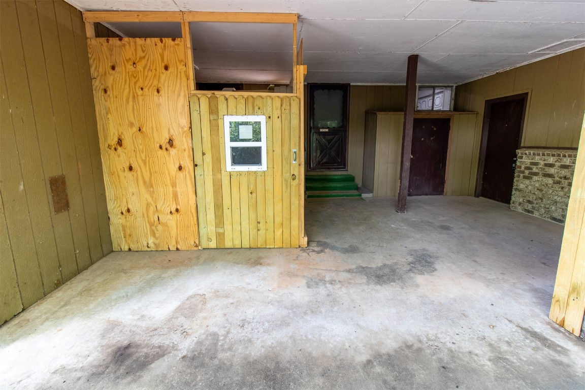 119 W Tennyson Avenue, Tecumseh, OK 74873 unfurnished room featuring wooden walls and concrete floors