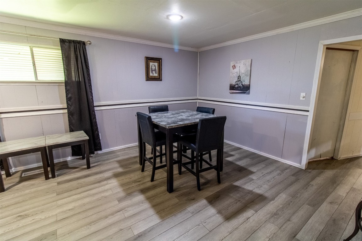 119 W Tennyson Avenue, Tecumseh, OK 74873 dining room featuring ornamental molding and light hardwood / wood-style flooring