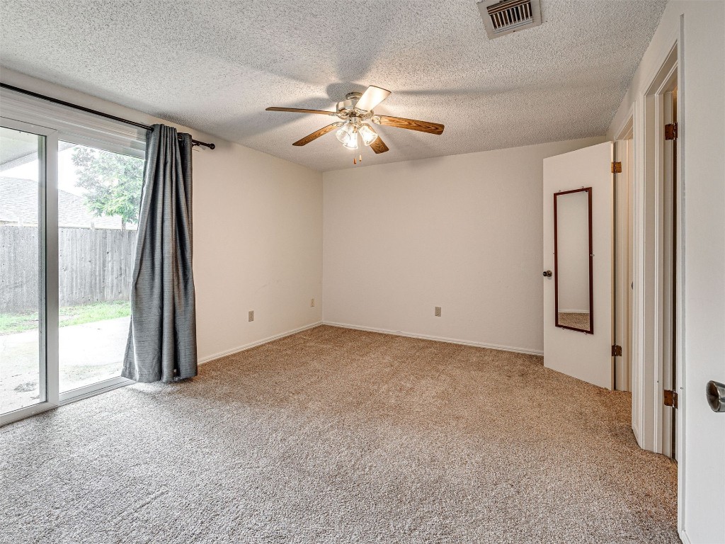 7613 NW 113th Place, Oklahoma City, OK 73162 carpeted empty room with ceiling fan and a textured ceiling
