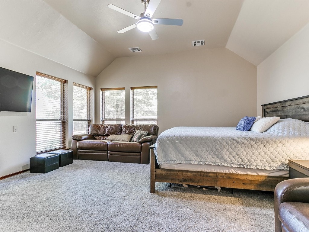 749 Gallant Fox Court, Edmond, OK 73025 carpeted bedroom with ceiling fan and vaulted ceiling