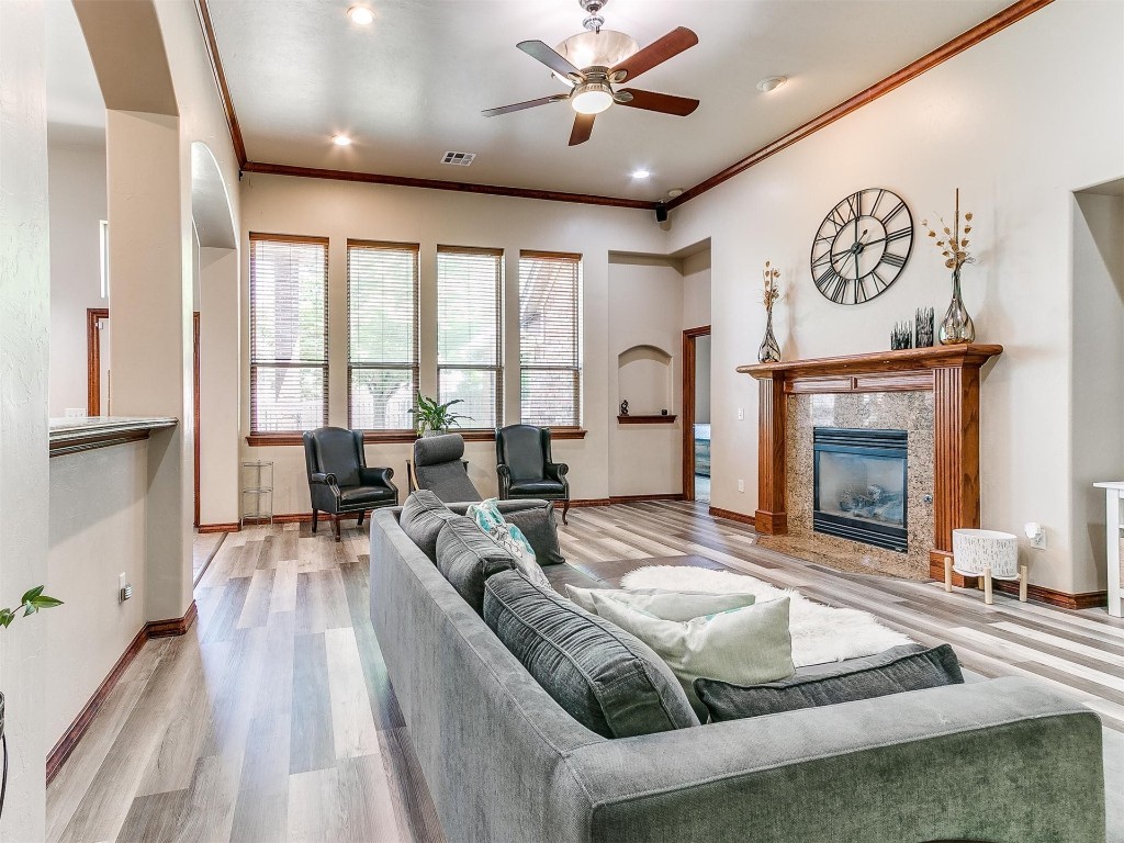 749 Gallant Fox Court, Edmond, OK 73025 living room with a premium fireplace, hardwood / wood-style floors, ceiling fan, and ornamental molding
