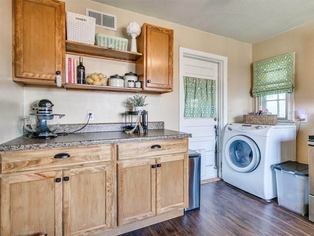 2403 Oxford Way, Oklahoma City, OK 73120 laundry area with dark hardwood / wood-style floors, cabinets, and washer / dryer