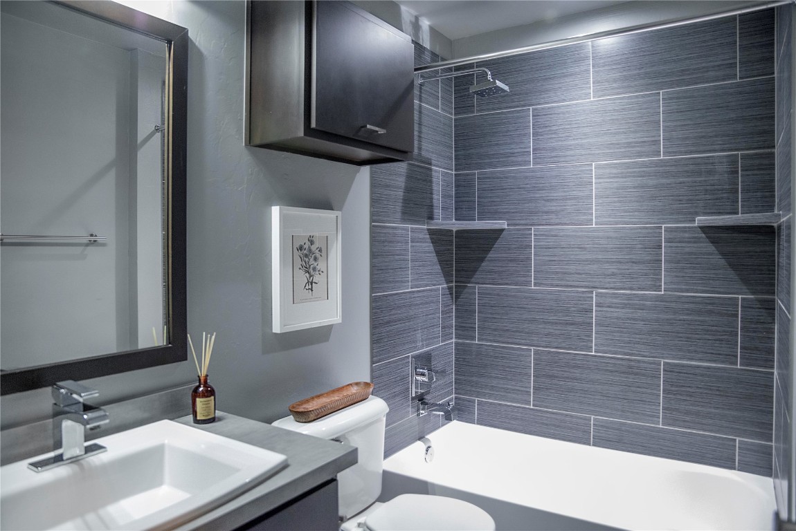 17308 Shadow Hawk Lane, Edmond, OK 73012 full bathroom featuring oversized vanity, toilet, and tiled shower / bath