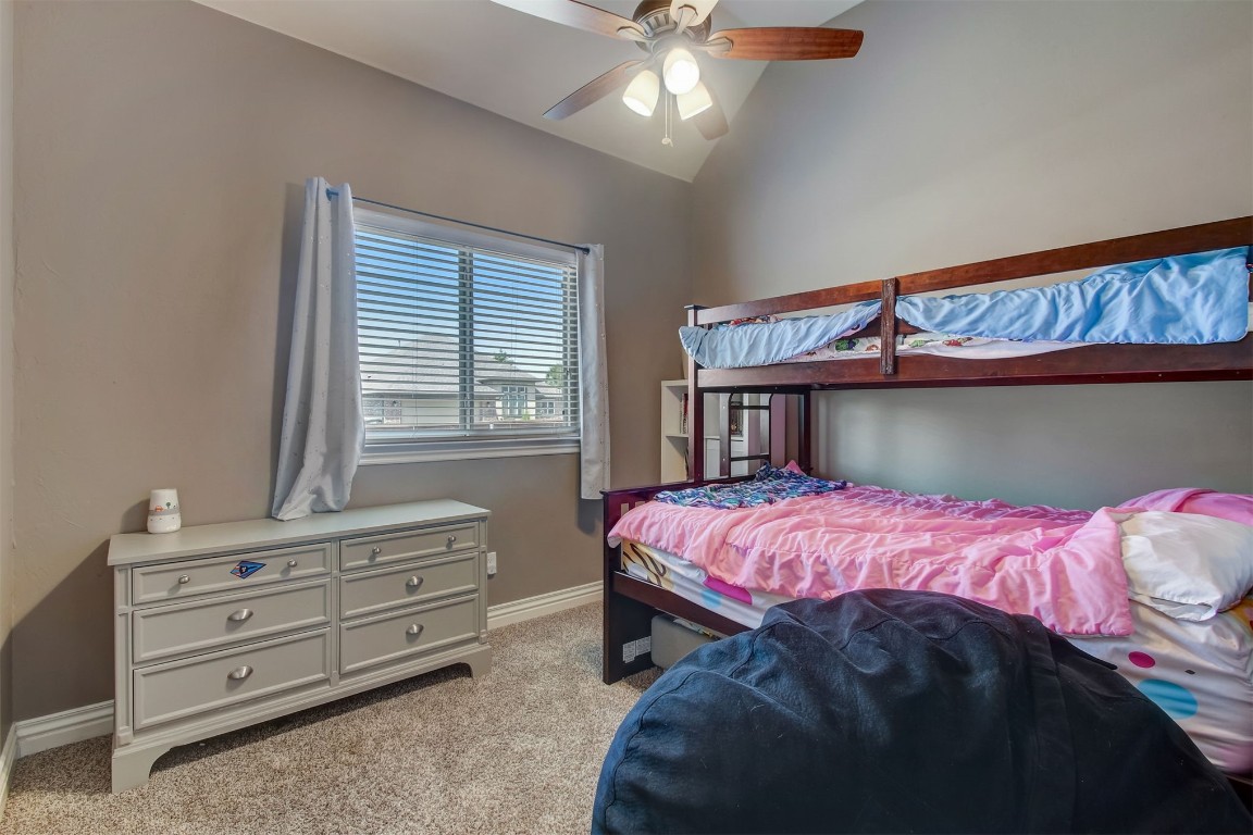 2816 Indian Grass Court, Edmond, OK 73013 carpeted bedroom with lofted ceiling and ceiling fan
