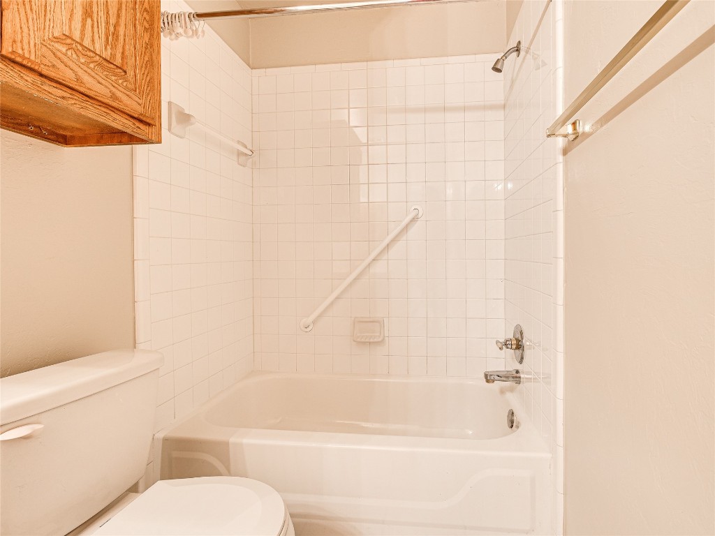 6913 NW 133rd Terrace, Oklahoma City, OK 73142 bathroom with tiled shower / bath and toilet