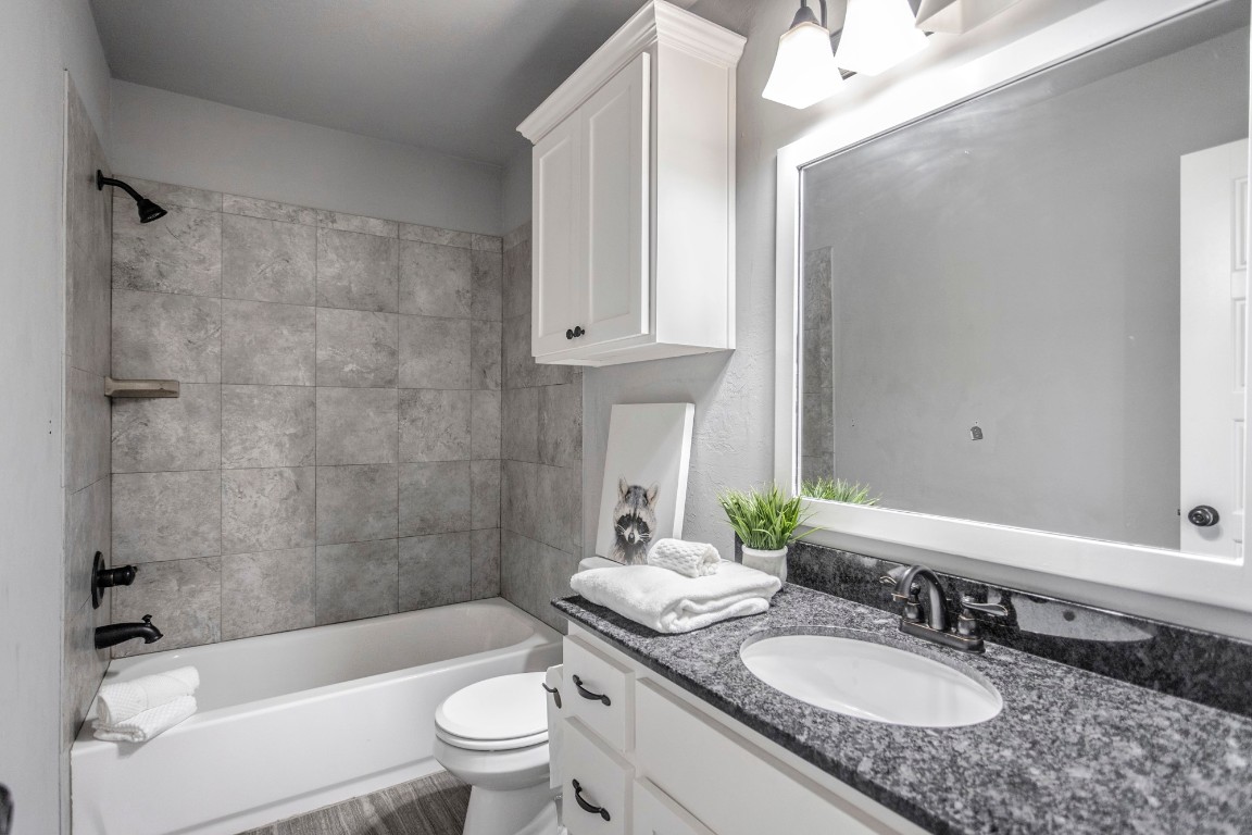 4604 Oasis Lane, Yukon, OK 73099 full bathroom featuring vanity, toilet, and tiled shower / bath