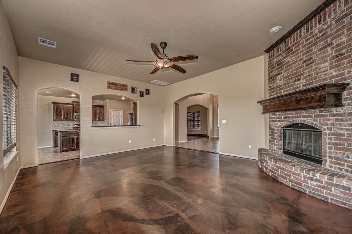 14509 Almond Valley Drive, Oklahoma City, OK 73165 unfurnished living room with ceiling fan and a fireplace