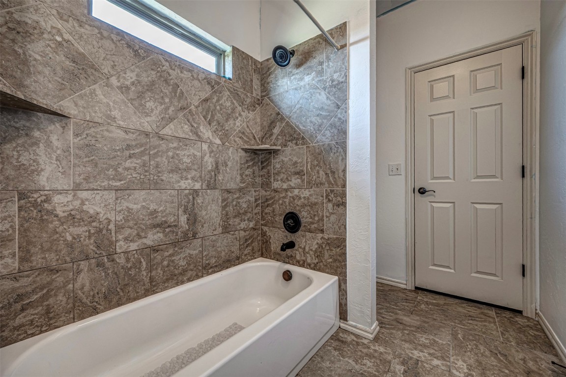 14509 Almond Valley Drive, Oklahoma City, OK 73165 bathroom featuring tiled shower / bath combo and tile floors