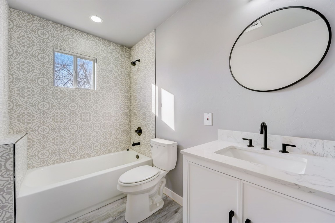 1721 N Jordan Avenue, Oklahoma City, OK 73111 full bathroom featuring hardwood / wood-style flooring, vanity, tub / shower combination, and toilet