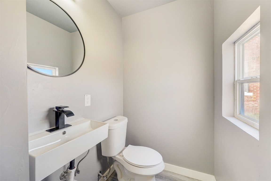 1721 N Jordan Avenue, Oklahoma City, OK 73111 bathroom with a healthy amount of sunlight, sink, wood-type flooring, and toilet