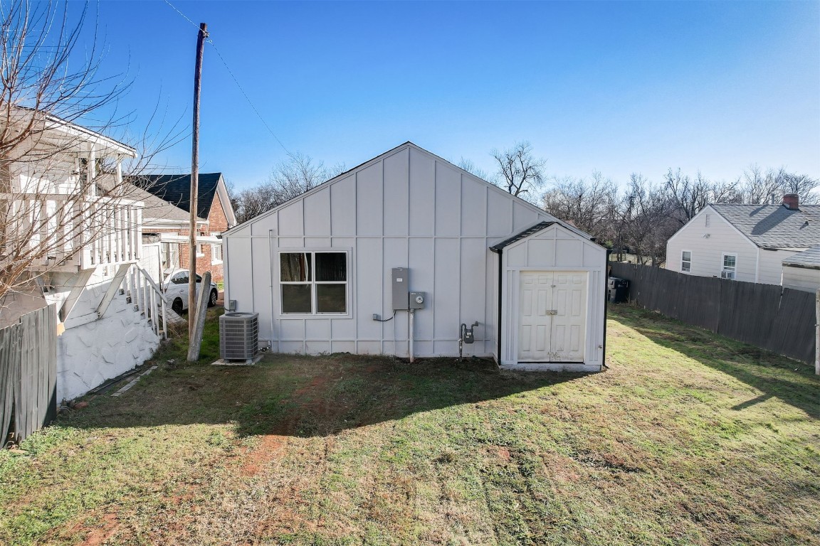1721 N Jordan Avenue, Oklahoma City, OK 73111 back of property featuring a yard, a storage unit, and central AC unit