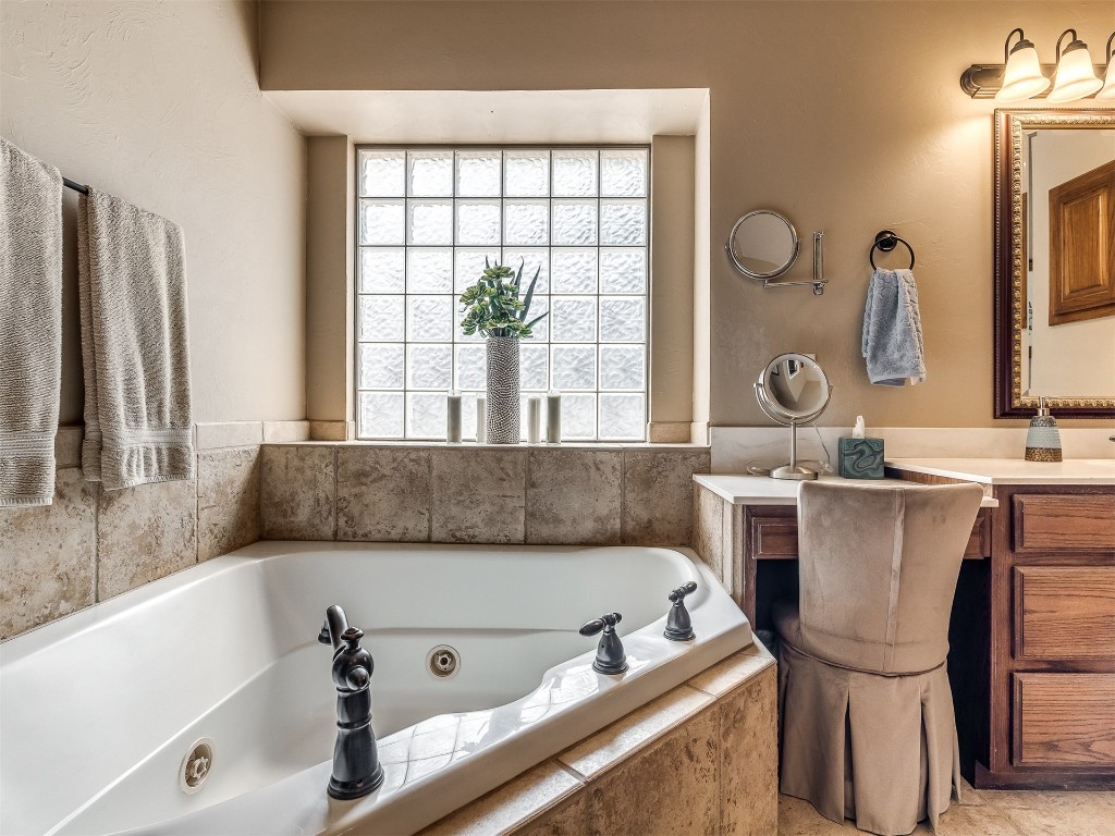10621 Sundance Avenue, Yukon, OK 73099 bathroom with a relaxing tiled bath and vanity