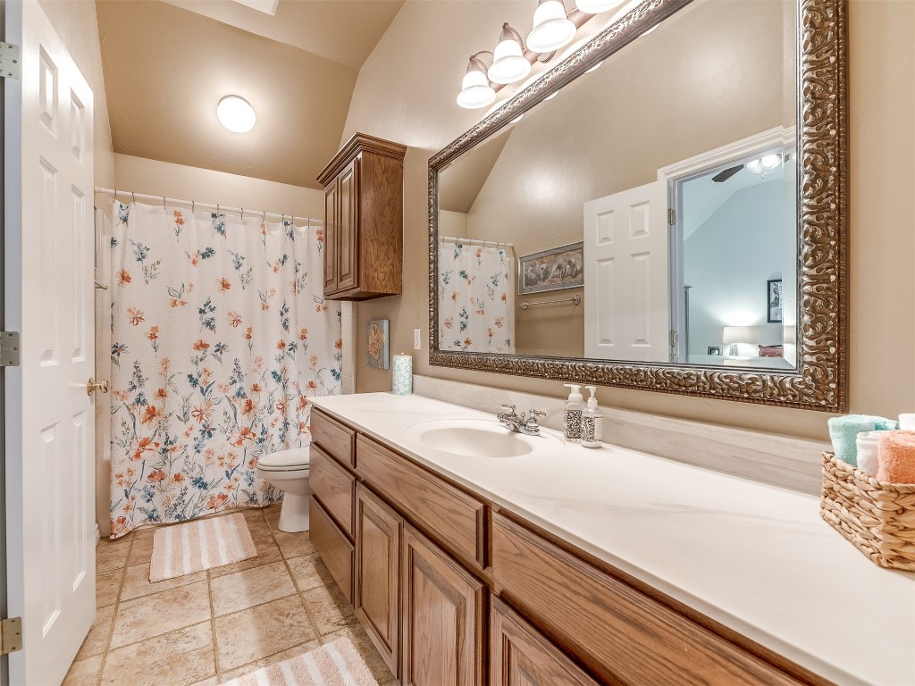 10621 Sundance Avenue, Yukon, OK 73099 bathroom featuring vanity, tile flooring, toilet, ceiling fan, and lofted ceiling