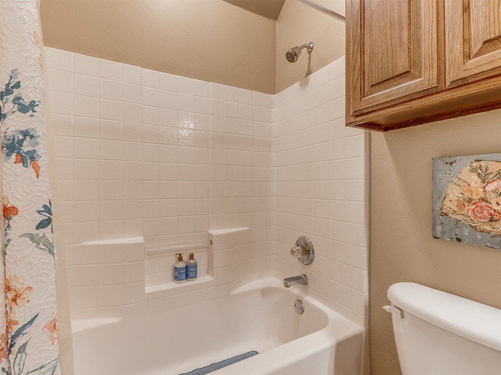 10621 Sundance Avenue, Yukon, OK 73099 bathroom featuring toilet and shower / bath combination with curtain