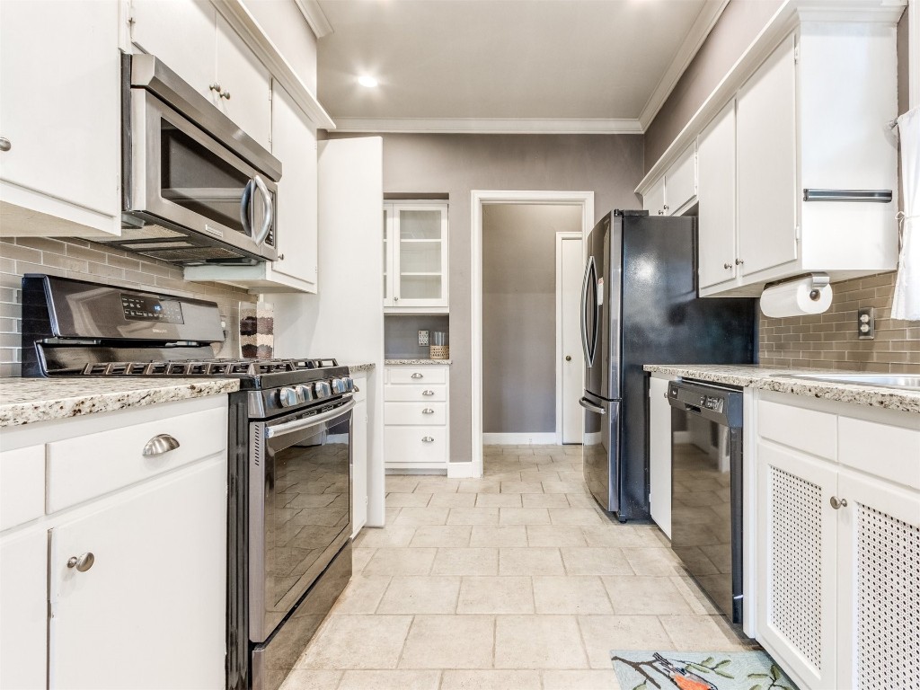 1008 NW 39th Street, Oklahoma City, OK 73118 kitchen with gas stove, light tile floors, tasteful backsplash, white cabinetry, and black dishwasher