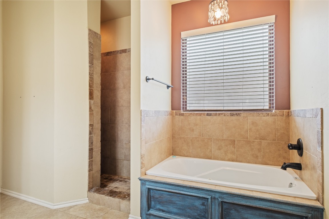 16209 Scissortail Drive, Edmond, OK 73013 bathroom with a washtub and tile flooring