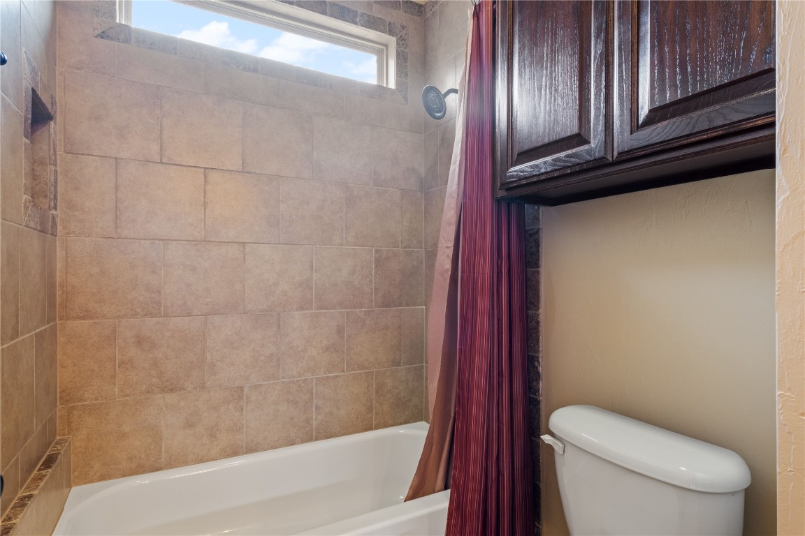 16209 Scissortail Drive, Edmond, OK 73013 bathroom with shower / bath combination with curtain and toilet