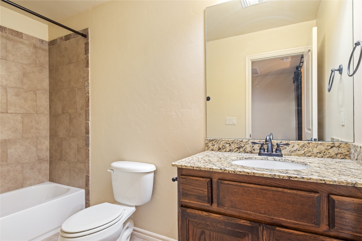 16209 Scissortail Drive, Edmond, OK 73013 full bathroom with vanity, tiled shower / bath combo, and toilet