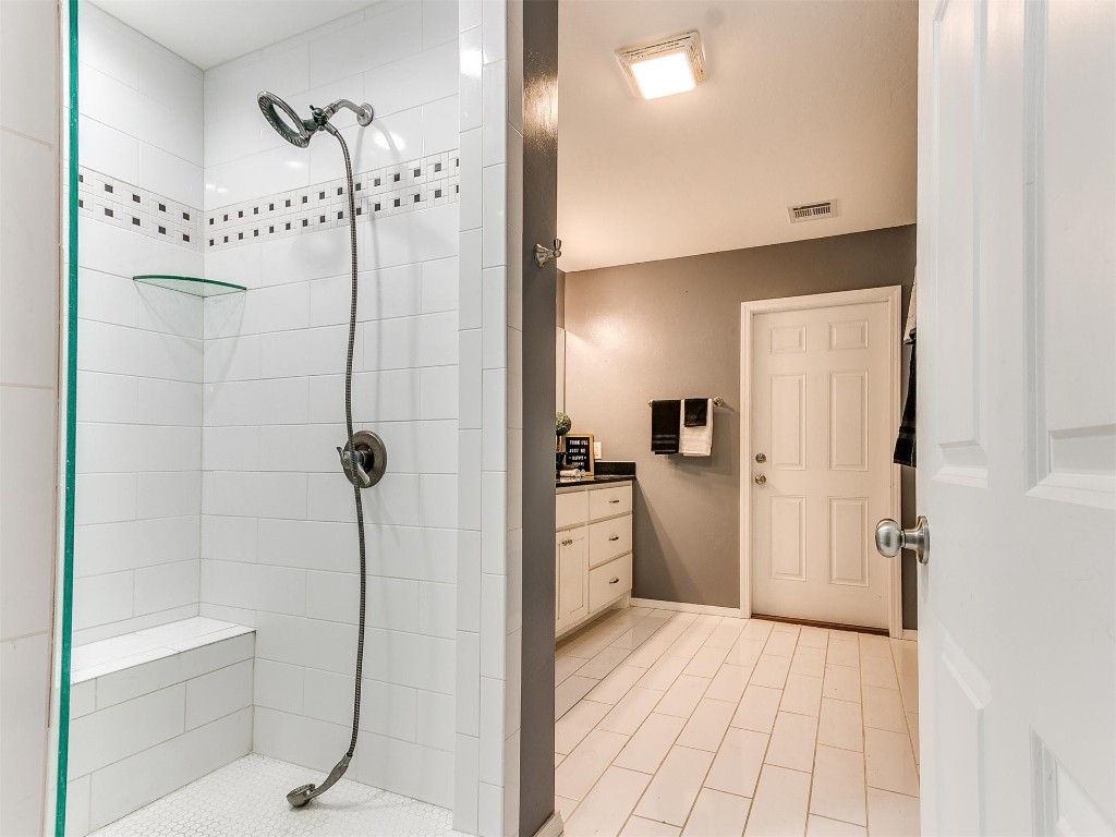 323 N Broad Street, Guthrie, OK 73044 bathroom featuring vanity, a tile shower, and tile flooring