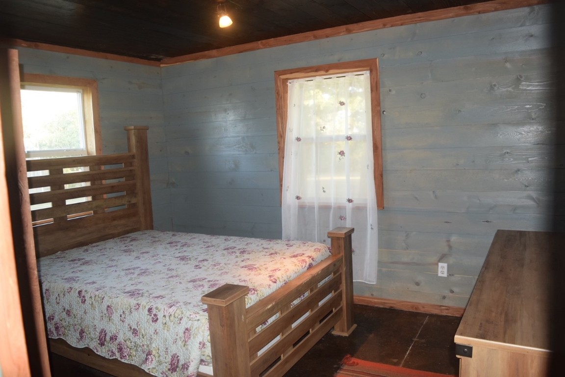 18633 N Santa Fe Avenue, Mulhall, OK 73063 bedroom featuring wooden walls