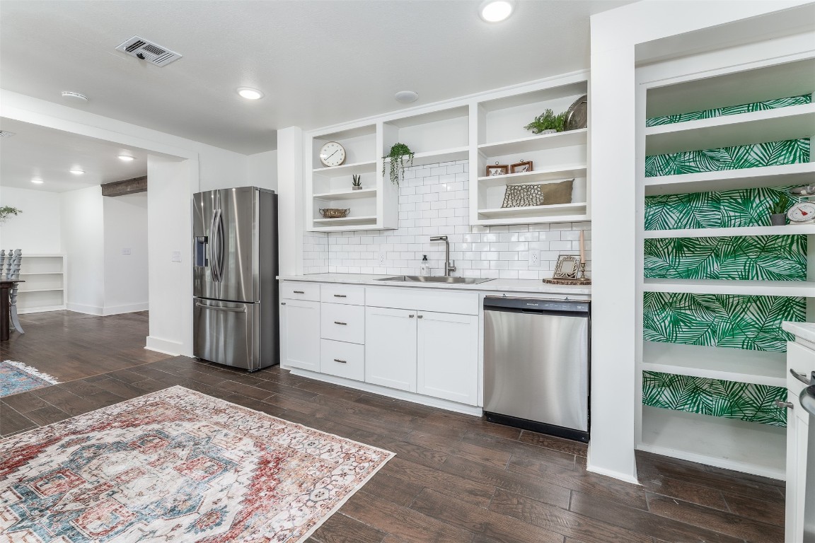 620 Nebraska Street, Norman, OK 73069 kitchen featuring appliances with stainless steel finishes, tasteful backsplash, white cabinetry, sink, and dark hardwood / wood-style flooring