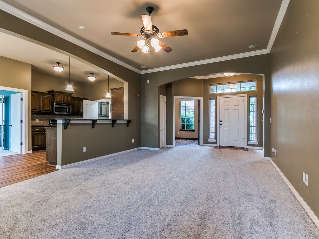 9101 Crooked Creek Lane, Moore, OK 73160 interior space with ornamental molding, light carpet, and ceiling fan