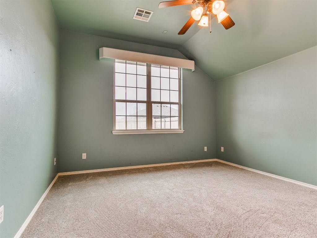 9101 Crooked Creek Lane, Moore, OK 73160 spare room featuring carpet, ceiling fan, and vaulted ceiling