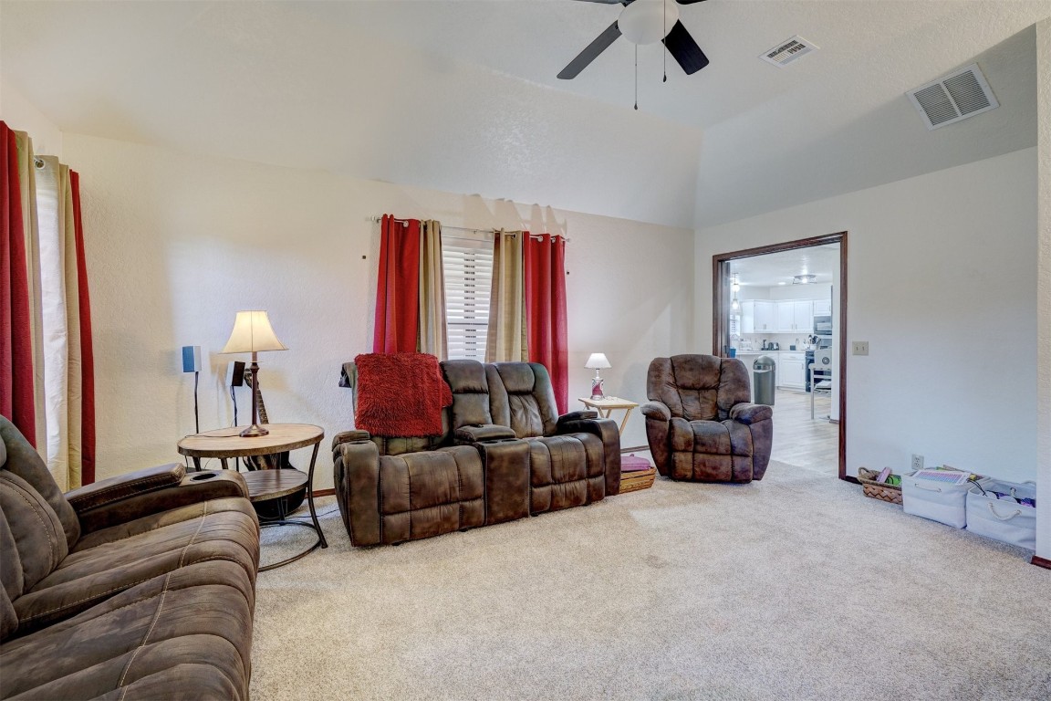 1816 NW 176th Street, Edmond, OK 73012 living room with ceiling fan, vaulted ceiling, and carpet