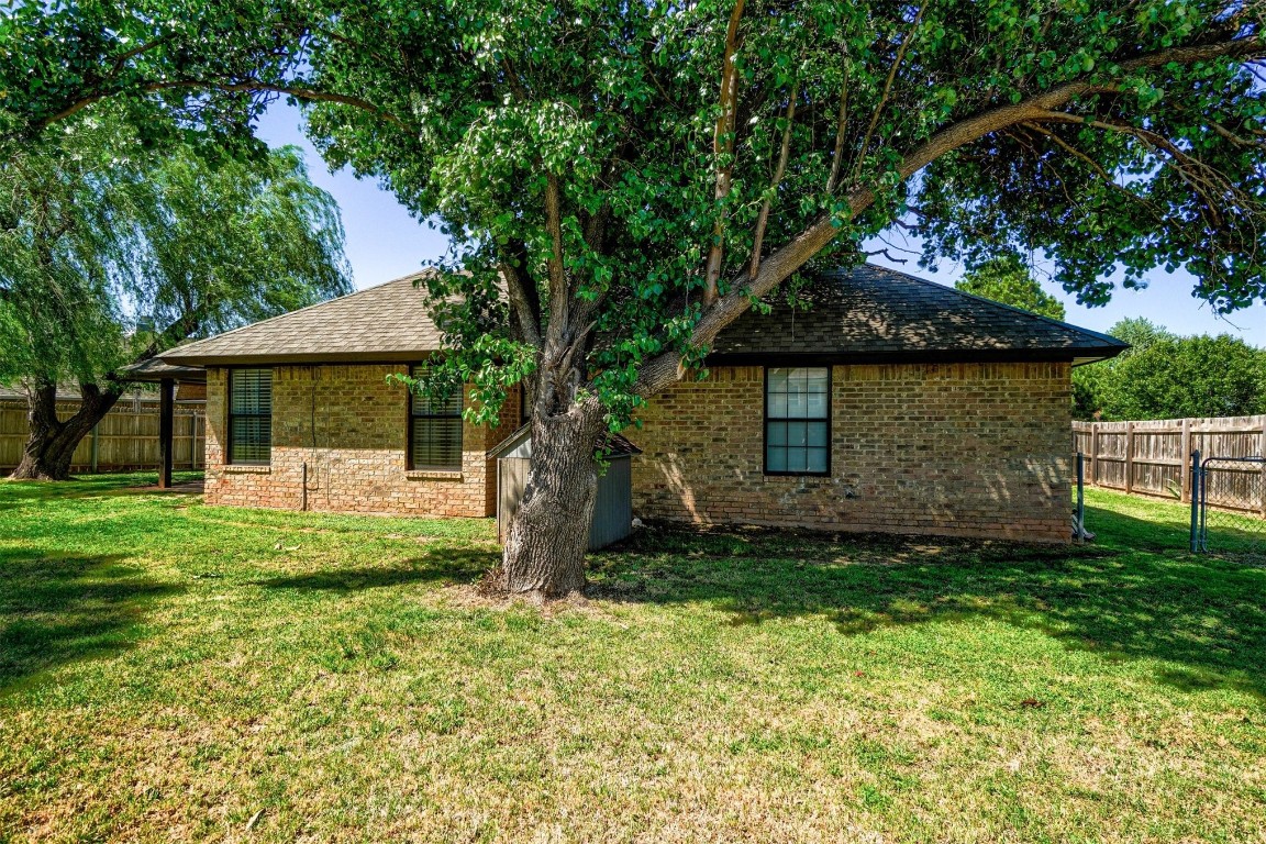 1816 NW 176th Street, Edmond, OK 73012 rear view of house with a yard