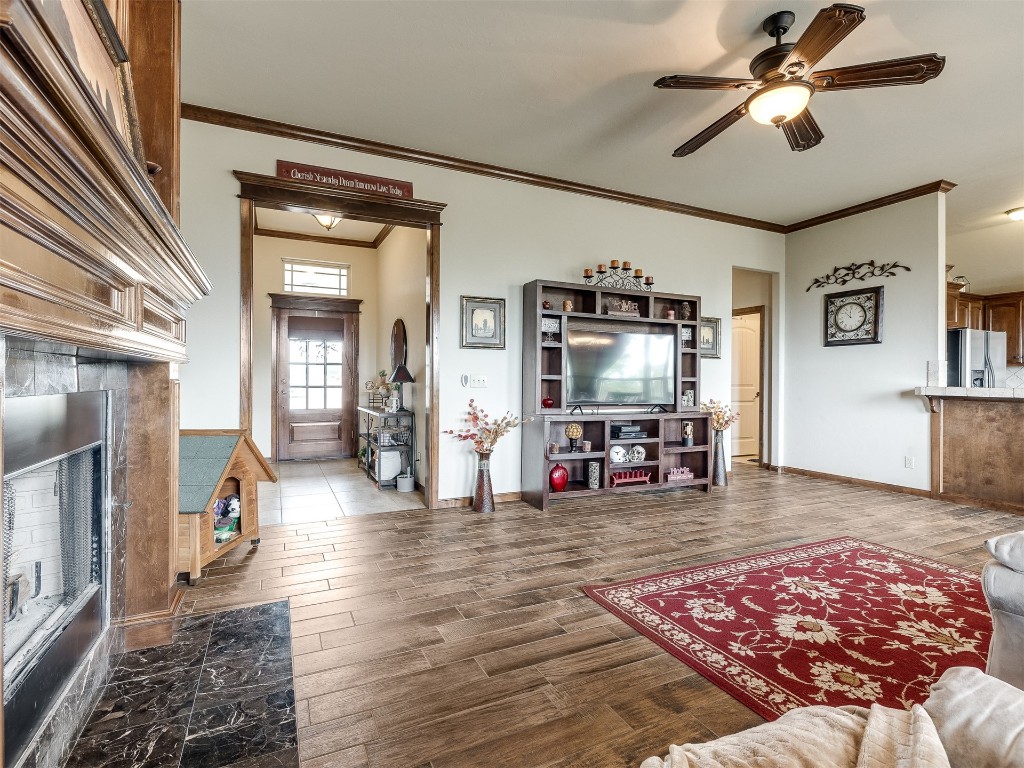 10521 NW 49th Street, Yukon, OK 73099 living room featuring hardwood / wood-style floors, ceiling fan, and crown molding
