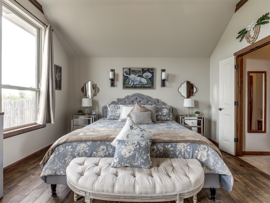 10521 NW 49th Street, Yukon, OK 73099 bedroom with hardwood / wood-style flooring and lofted ceiling