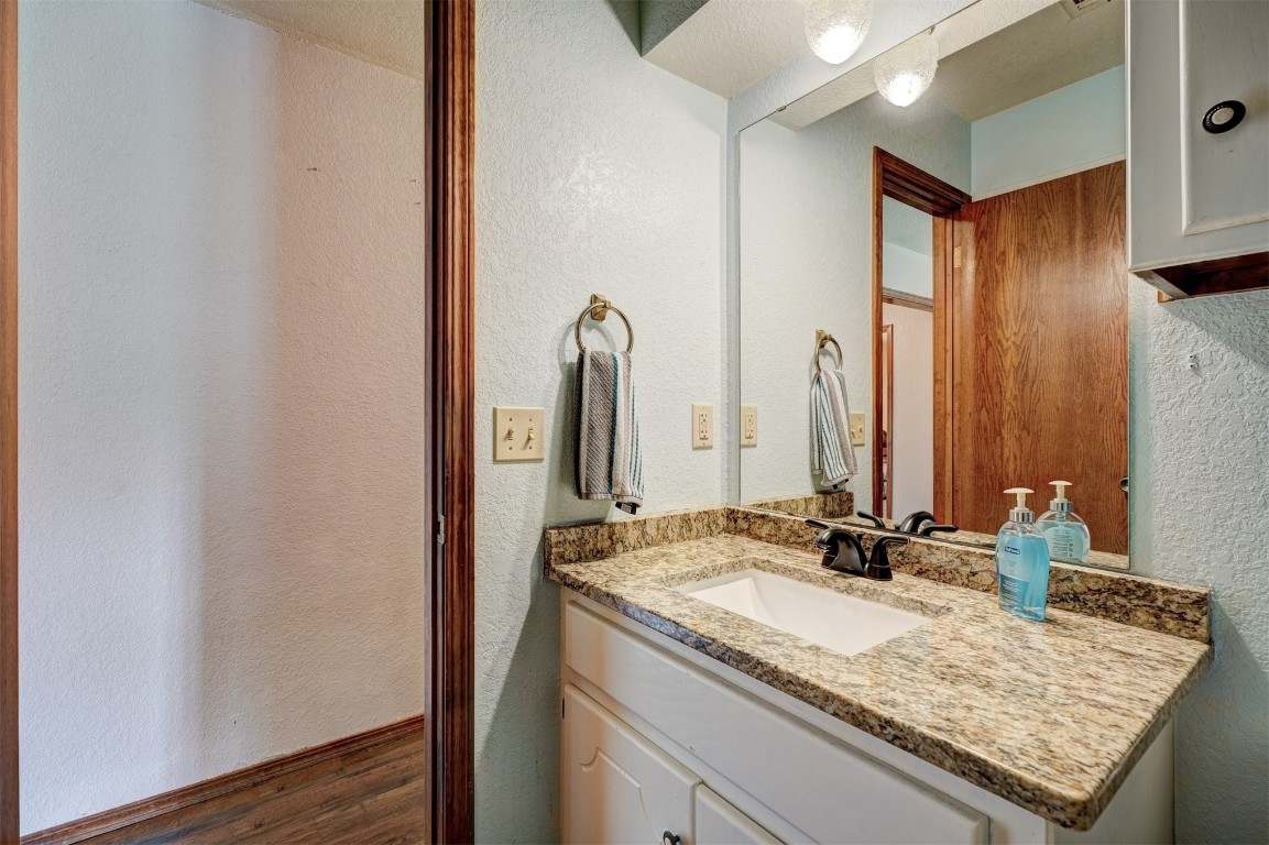 6404 S Peebly Road, Newalla, OK 74857 bathroom featuring a textured ceiling and large vanity