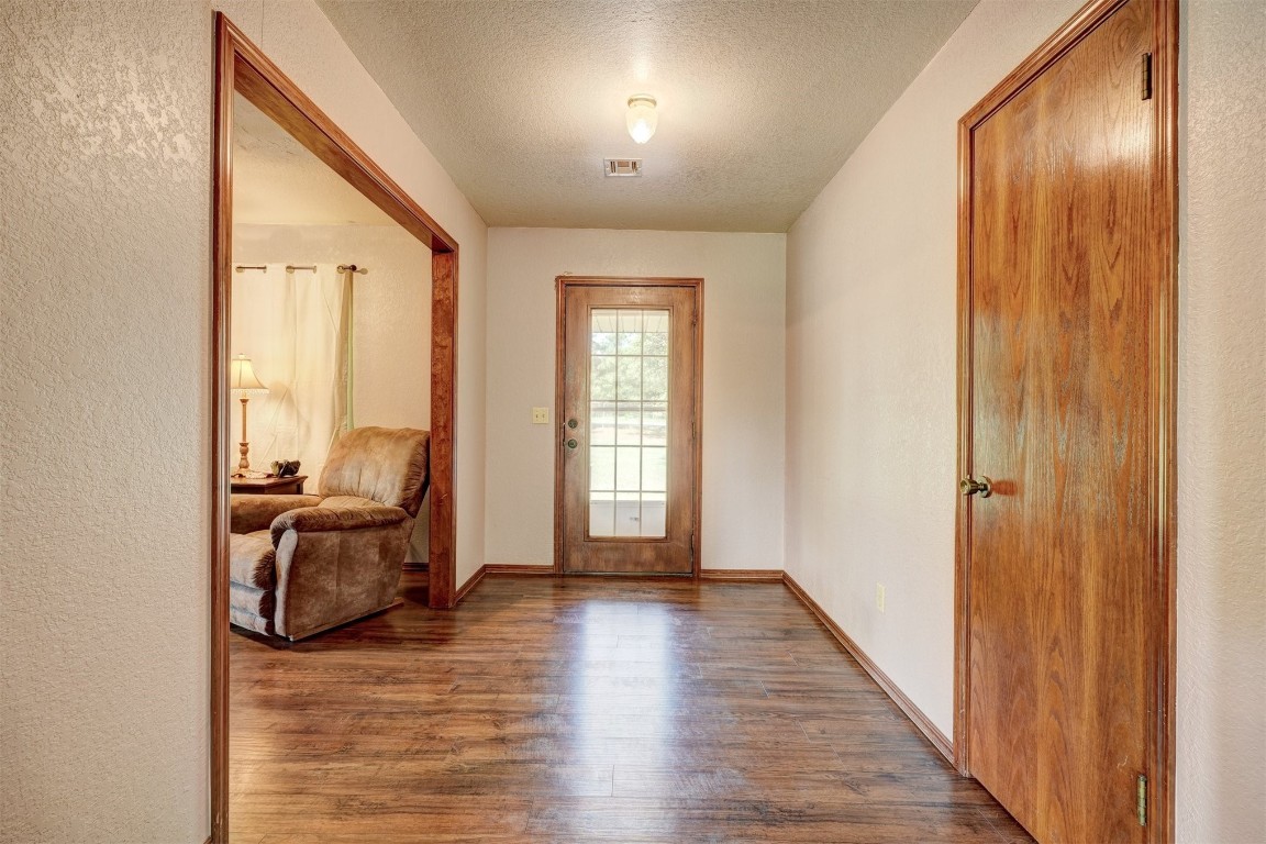 6404 S Peebly Road, Newalla, OK 74857 foyer entrance featuring a textured ceiling and hardwood / wood-style floors