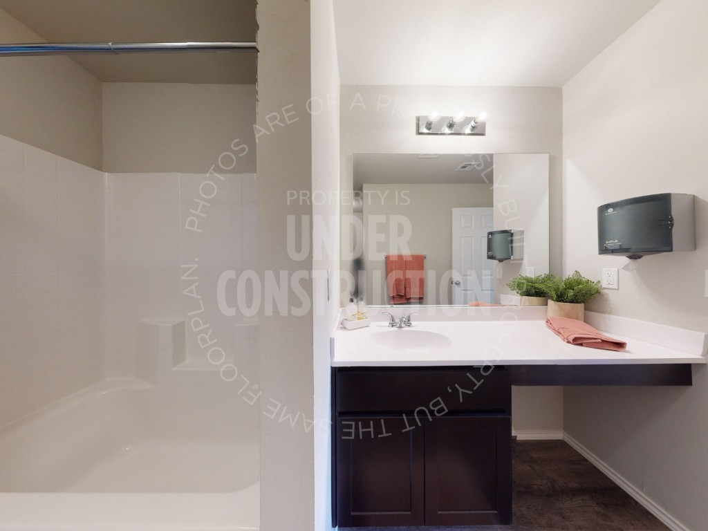 10024 SW 41st Street, Mustang, OK 73064 bathroom featuring hardwood / wood-style floors, shower / bathtub combination, and oversized vanity